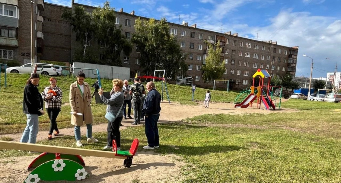 Люди на детской площадке около дома