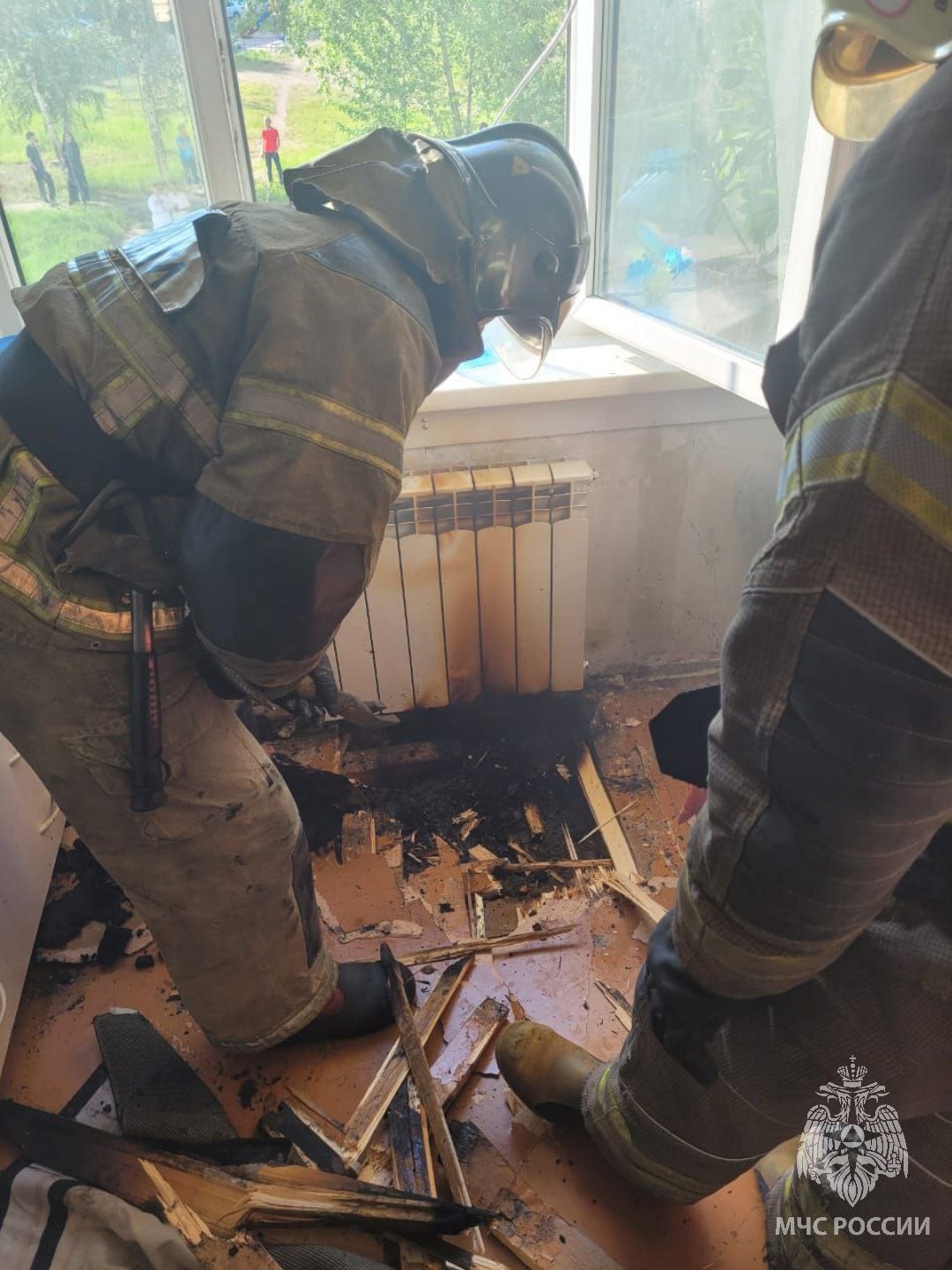 Пожарные устраняют последствия возгорания в квартире.