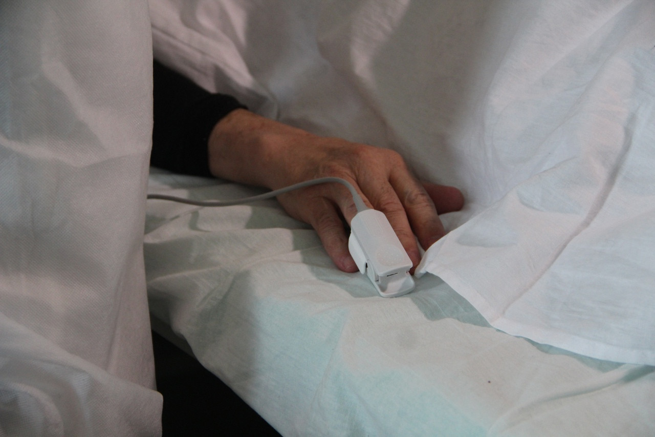 Рука с пульсоксиметром под покрывалом