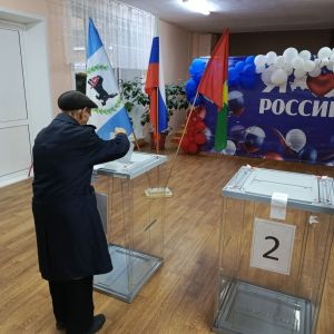 Пожилой человек голосует на избирательном участке.