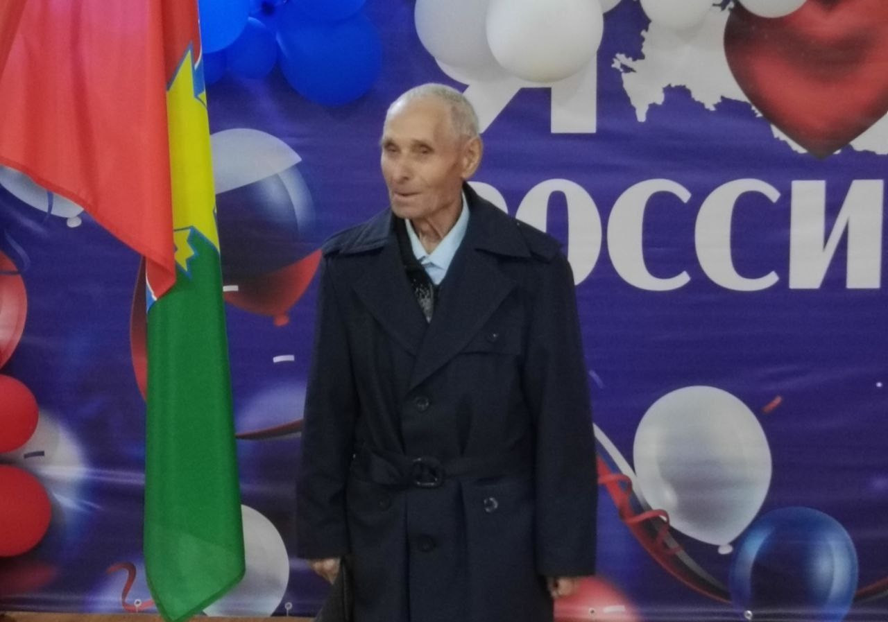 Мужчина возле флага России на фоне шаров