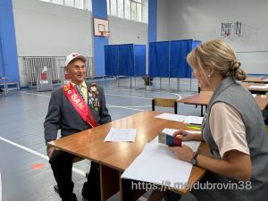 Ветеран обсуждает документы на избирательном участке.