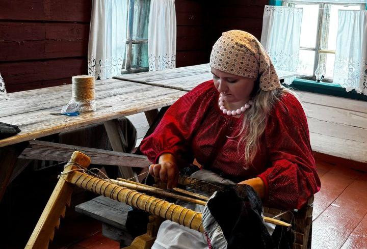 Женщина в традиционной одежде за ткацким станком.