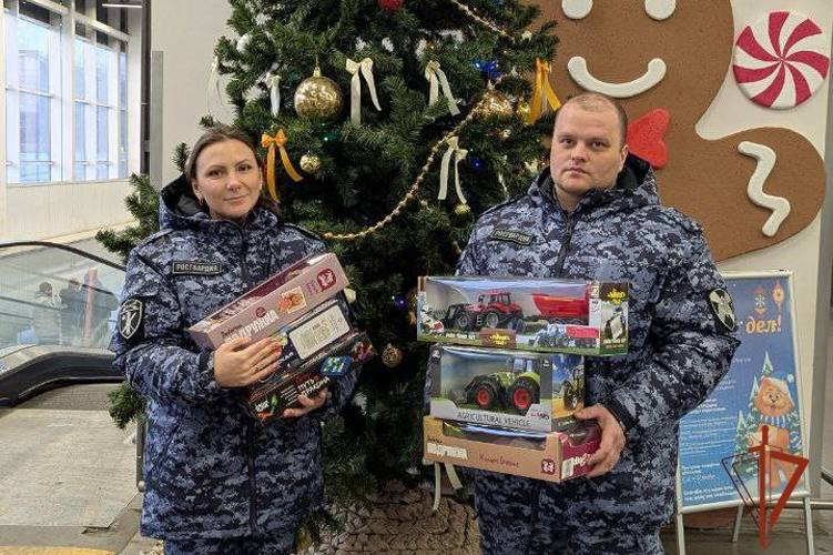 Полицейские держат игрушки у рождественской елки.