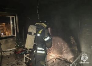 Пожарный осматривает поврежденное огнем помещение.