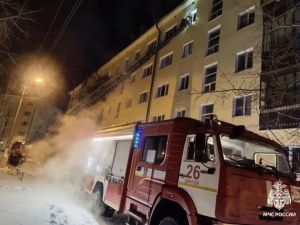 Пожарная машина у многоквартирного дома зимой.