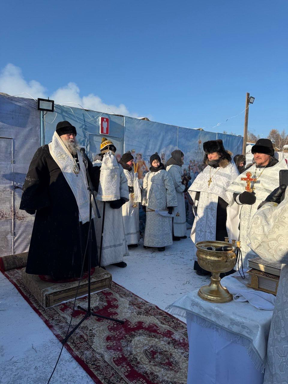 Православный обряд на улице зимой, священники молятся.