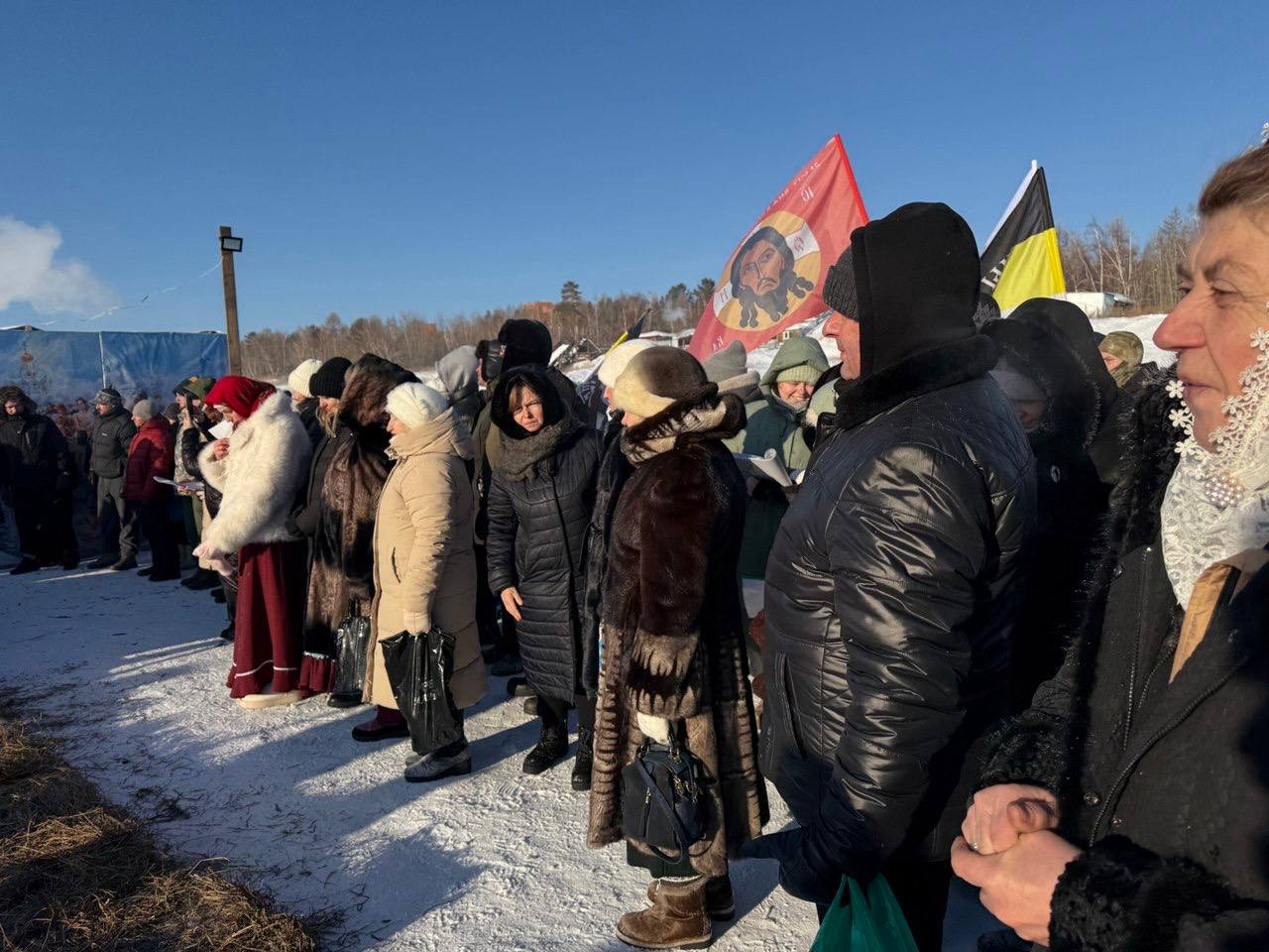 Люди на улице с флагами и снегом зимой.