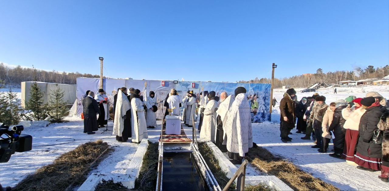 Христианский обряд у проруби на льду зимой.