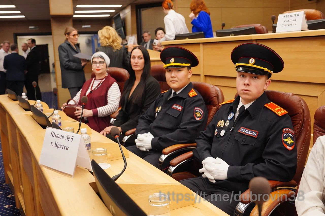 Ученики и педагоги в зале заседаний школы.