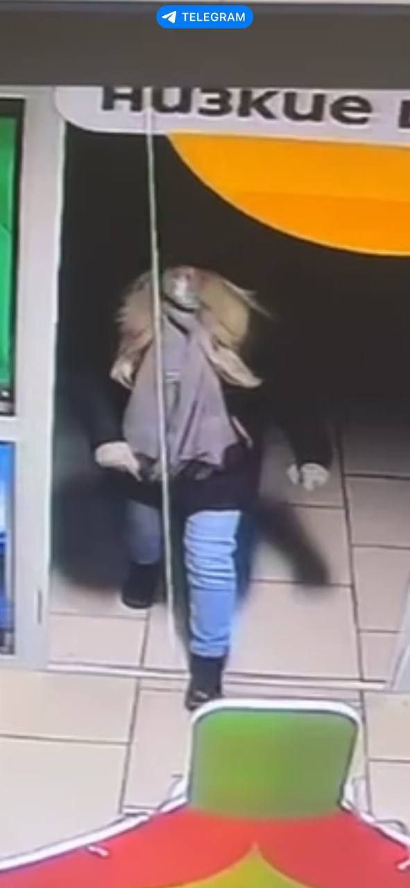 Человек в магазине под вывеской "Низкие цены".