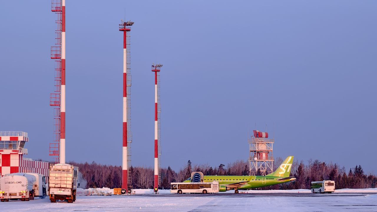 Самолет на заснеженном аэропортом фоне