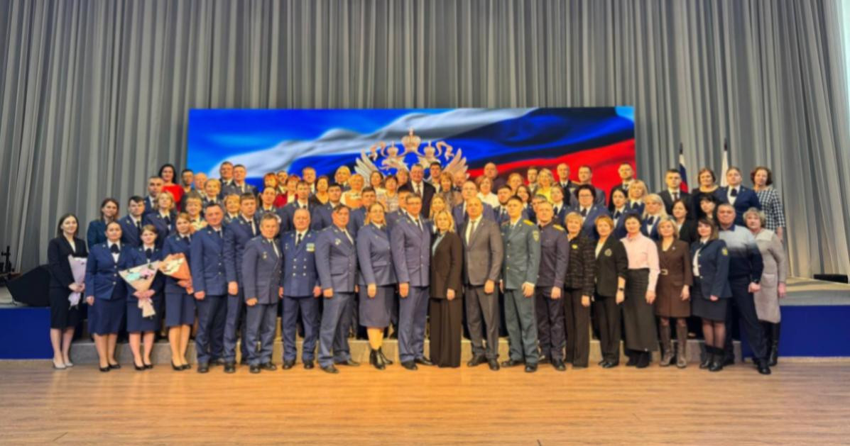 Группа людей на фоне российского флага.