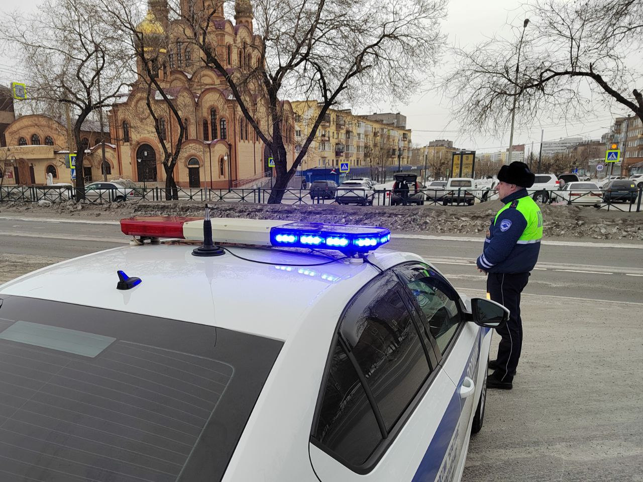 Полицейская машина с синей мигалкой на улице