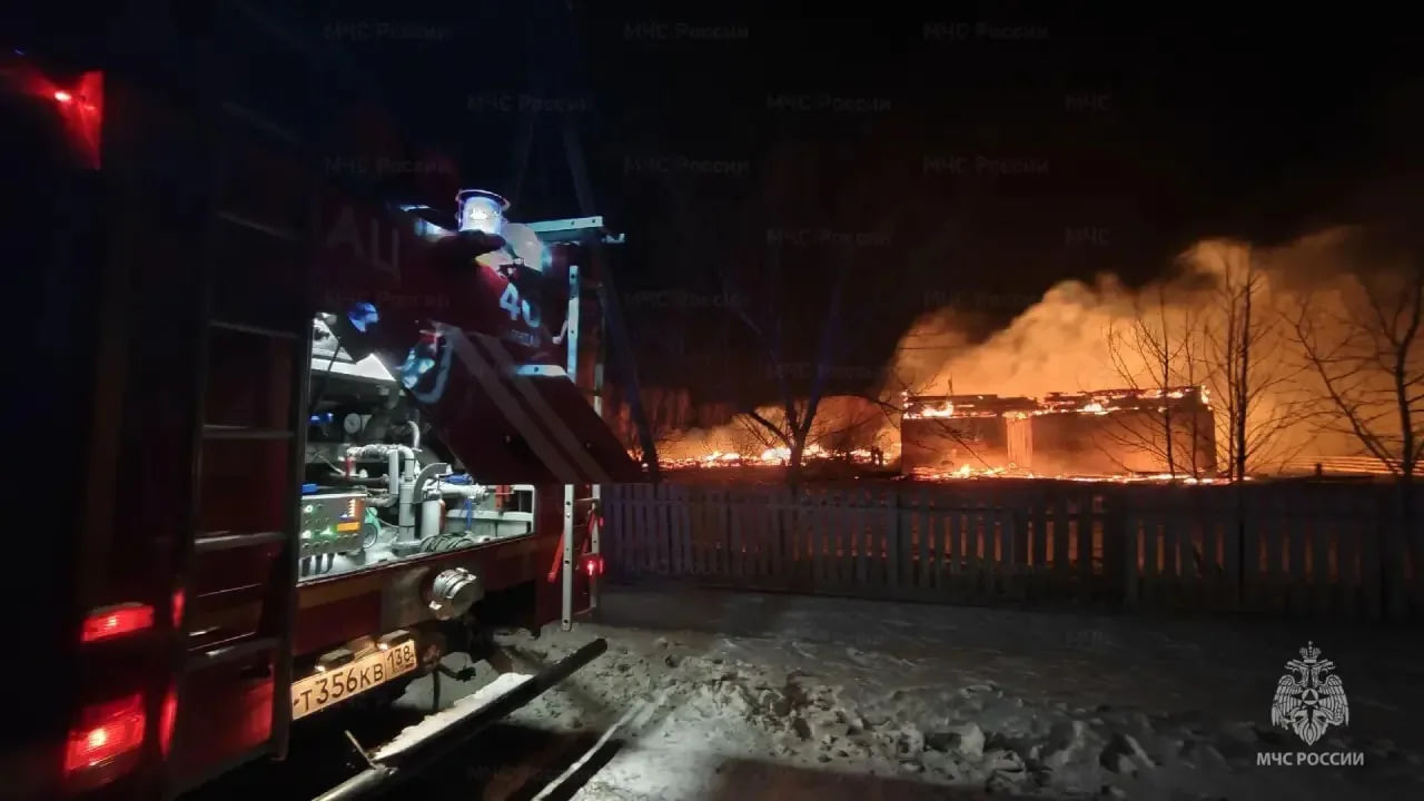 Пожарная машина у горящего здания ночью