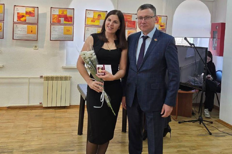 Пара на церемонии награждения с цветами.