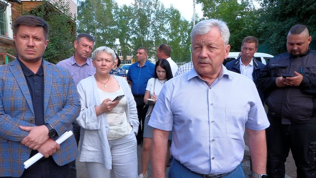 Группа людей на улице с телефонами.