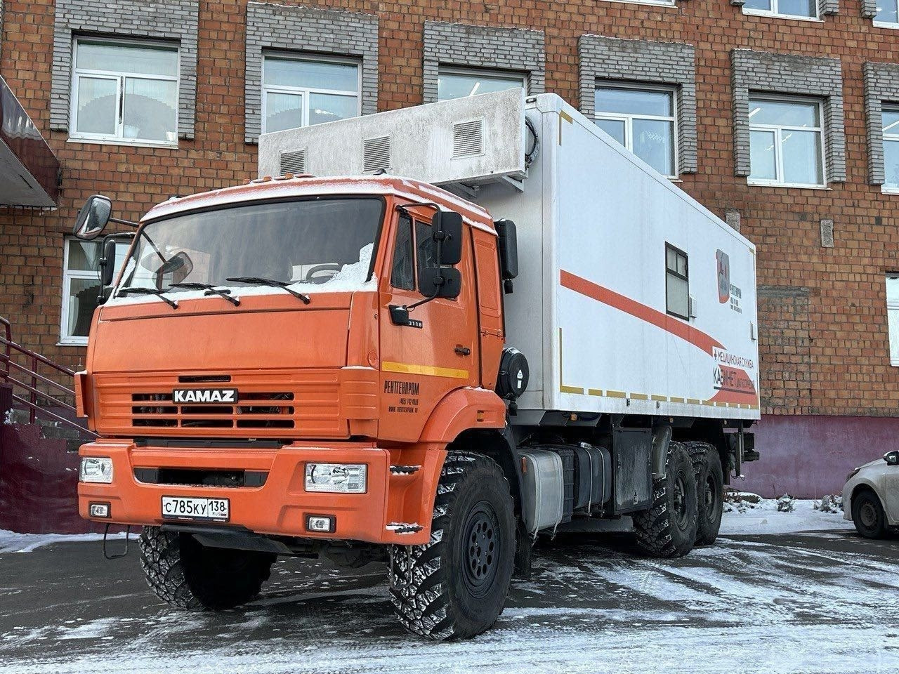 Грузовик Камаз перед зданием.
