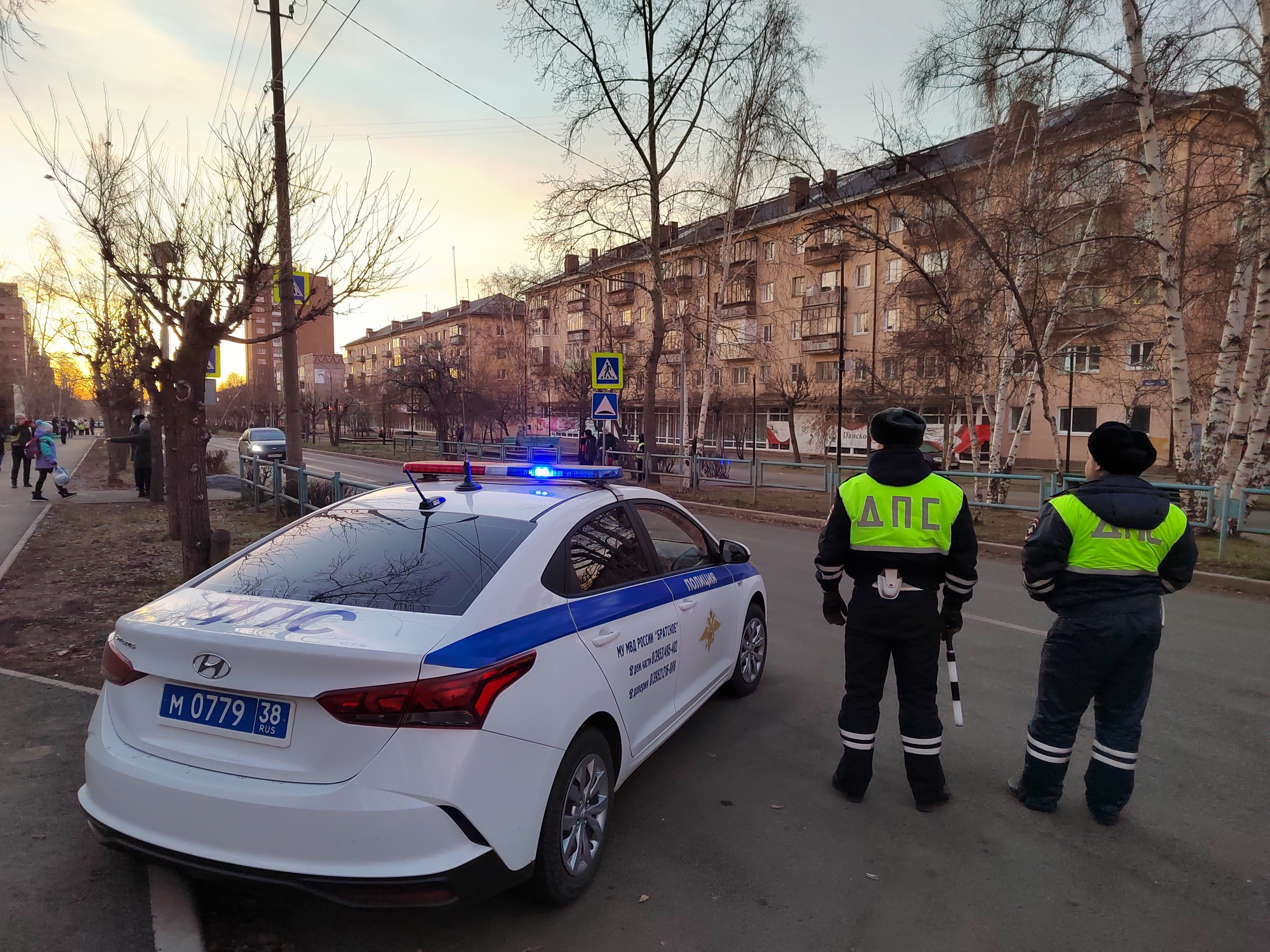 Автоинспекторы стоящие рядом с патрульной машиной