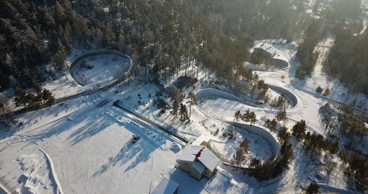 Зимний лес и извилистая трасса, вид сверху.