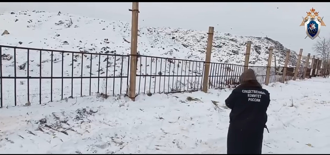 Заснеженная местность и человек у забора