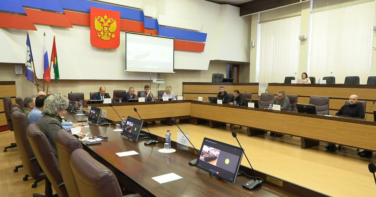 Заседание в зале с людьми за столами.