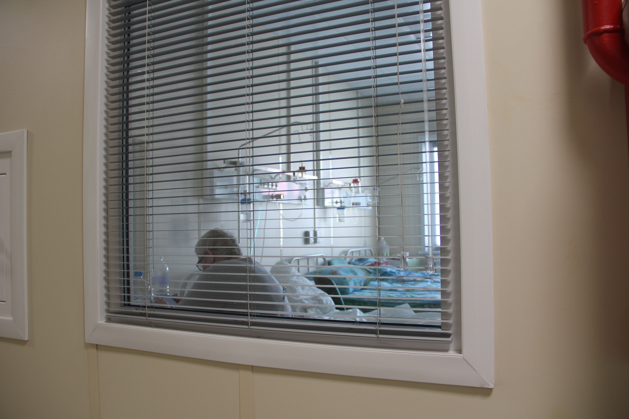 Пациент в больничной палате за жалюзи