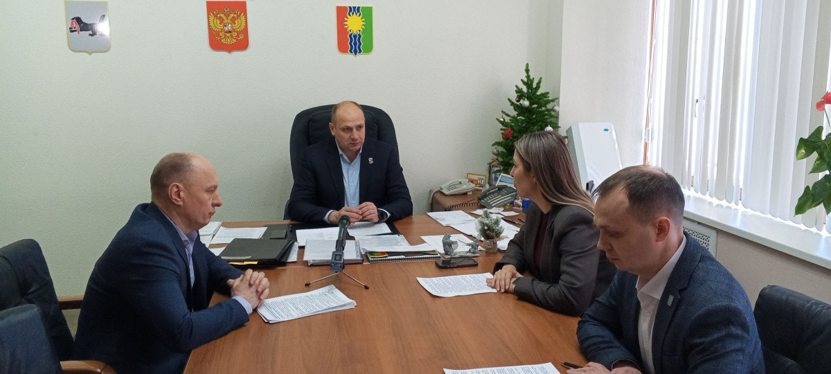 Совещание в офисе: четверо за столом обсуждают документы.