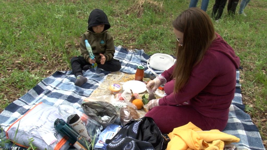 Пикник на природе: женщина и ребёнок на покрывале.