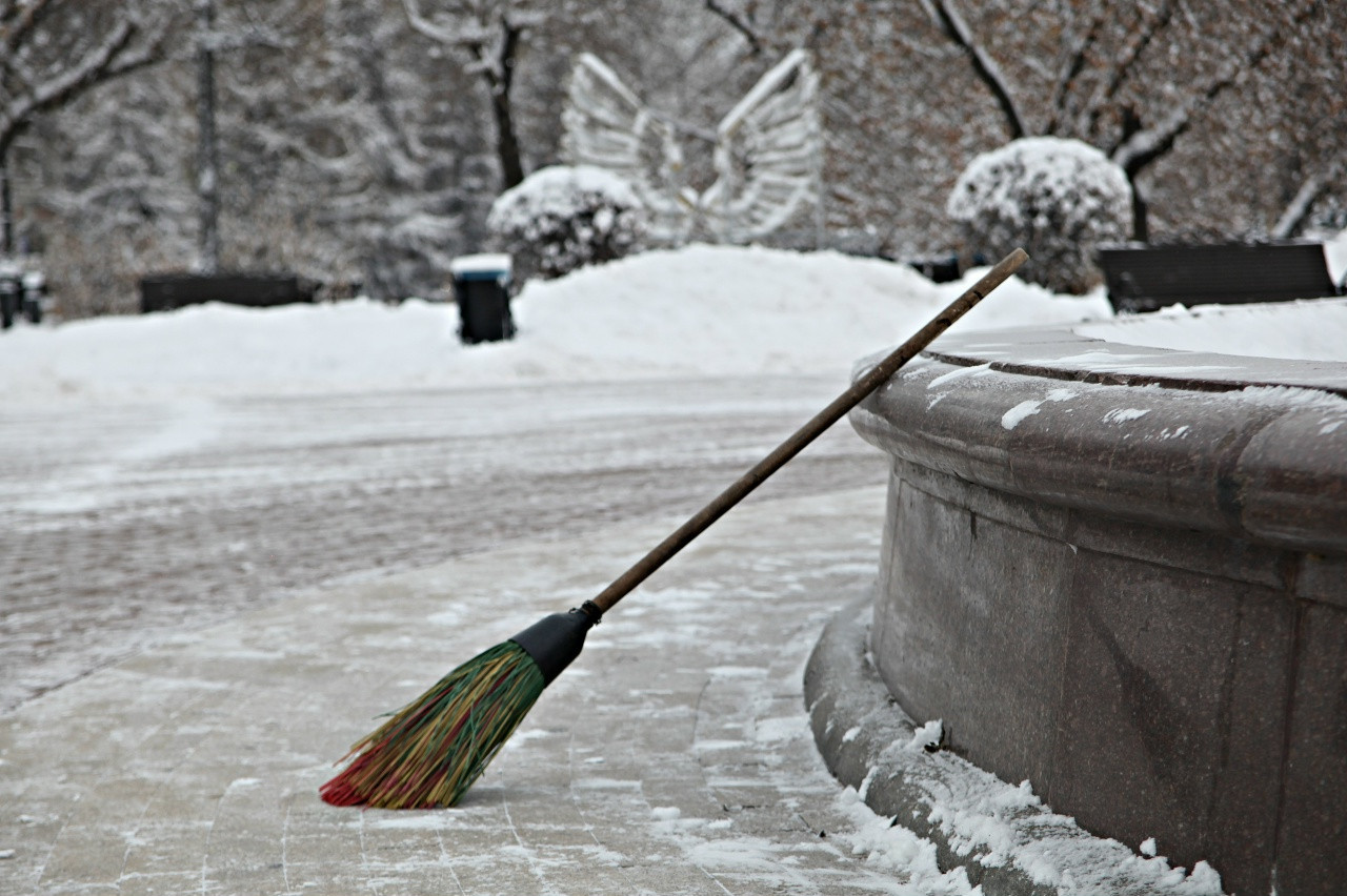 Метла у скамьи в заснеженном парке