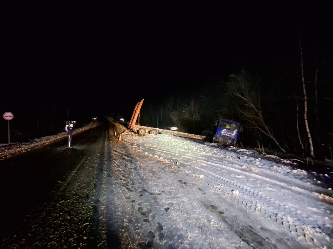 Грузовик на обочине ночью в снегу.
