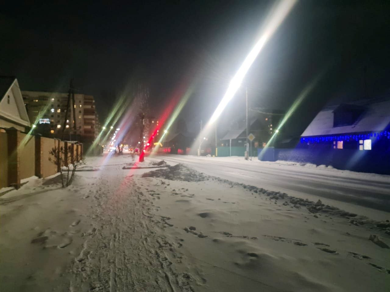 Зимняя ночь на заснеженной улице с фонарями.