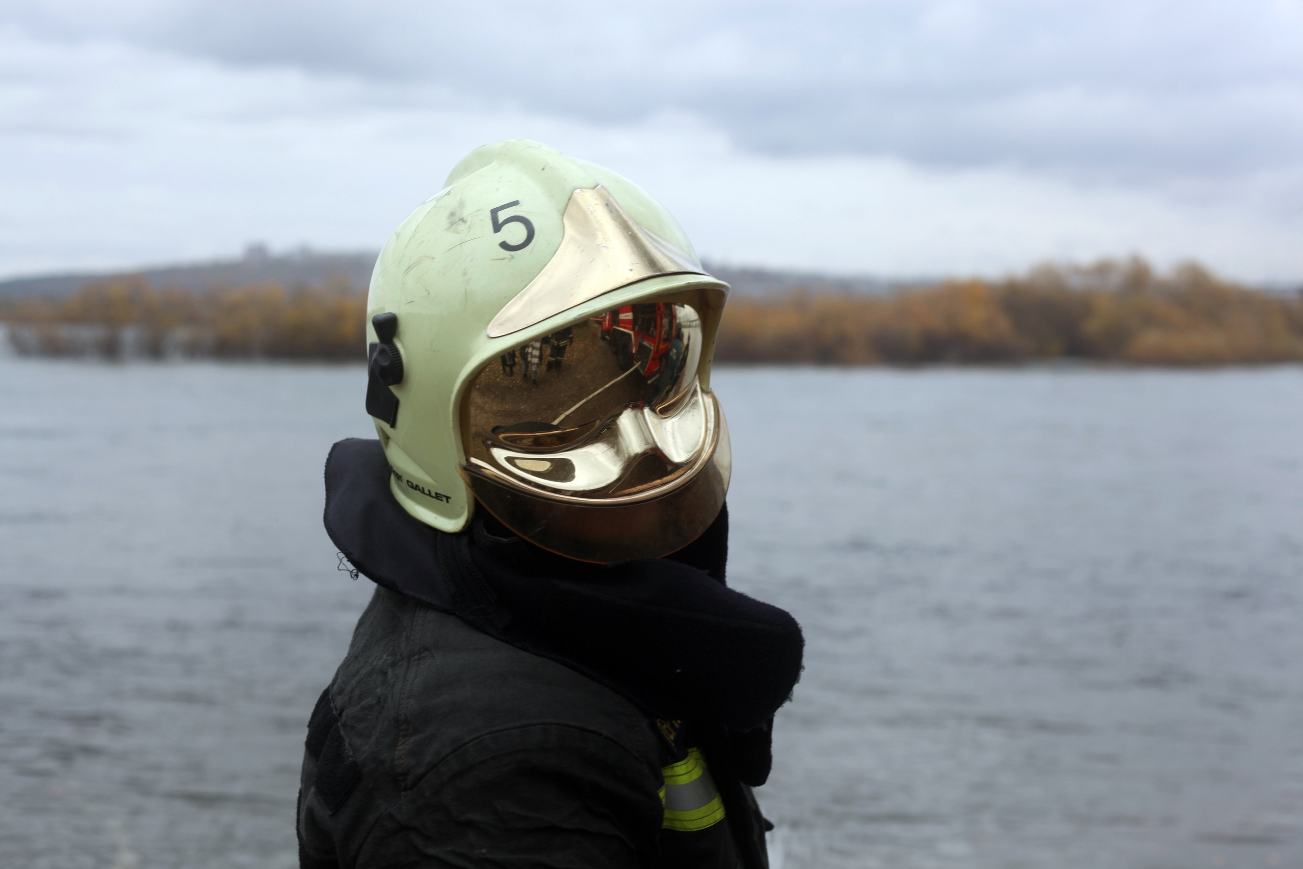 Пожарный у реки в защитной каске