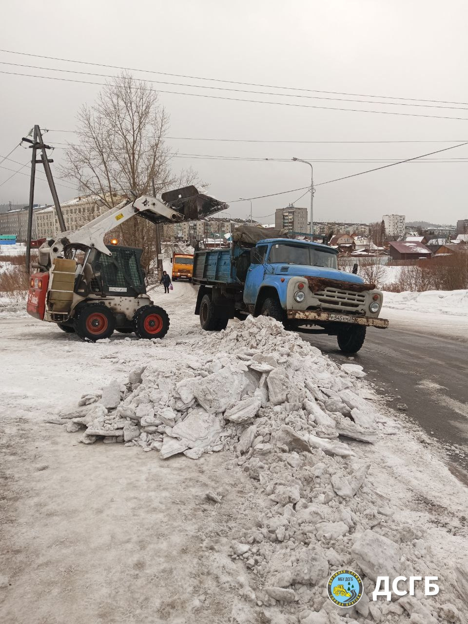 Погрузка снега в грузовик зимой